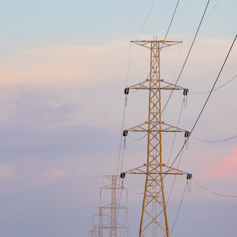 High voltage tower  and line cables, in sunset sky background
